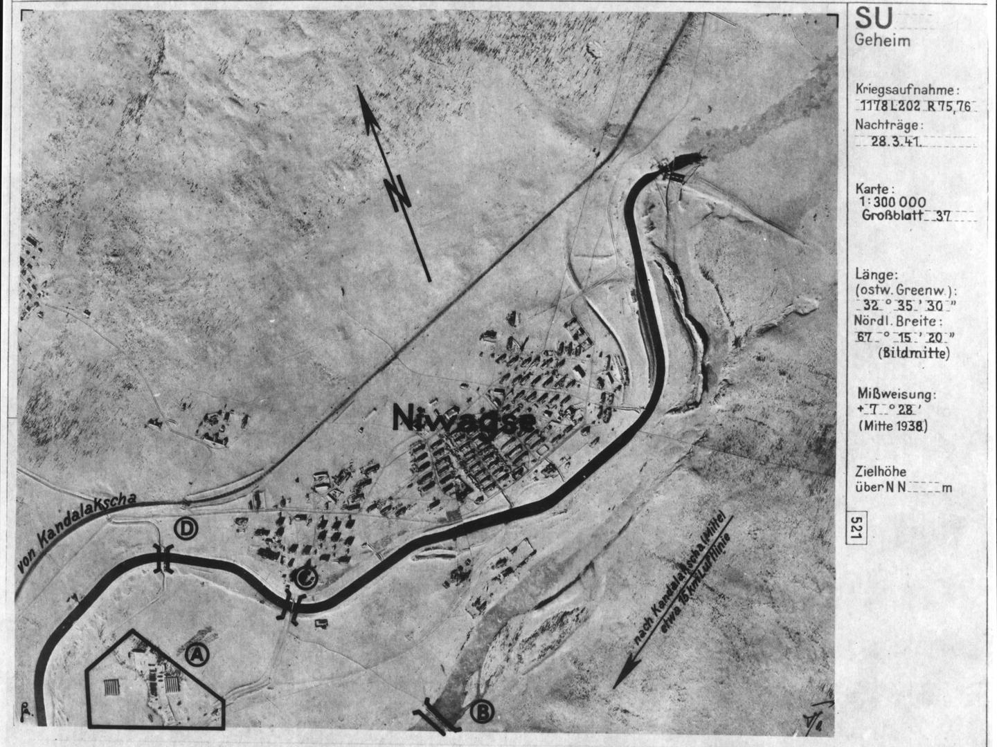 A black and white aerial photomap of a small settlement in a snowy landscape. A river runs diagonally across the image, which is annotated with letters and an arrow marked ‘N’ for north pointing up. German text runs along the right edge.