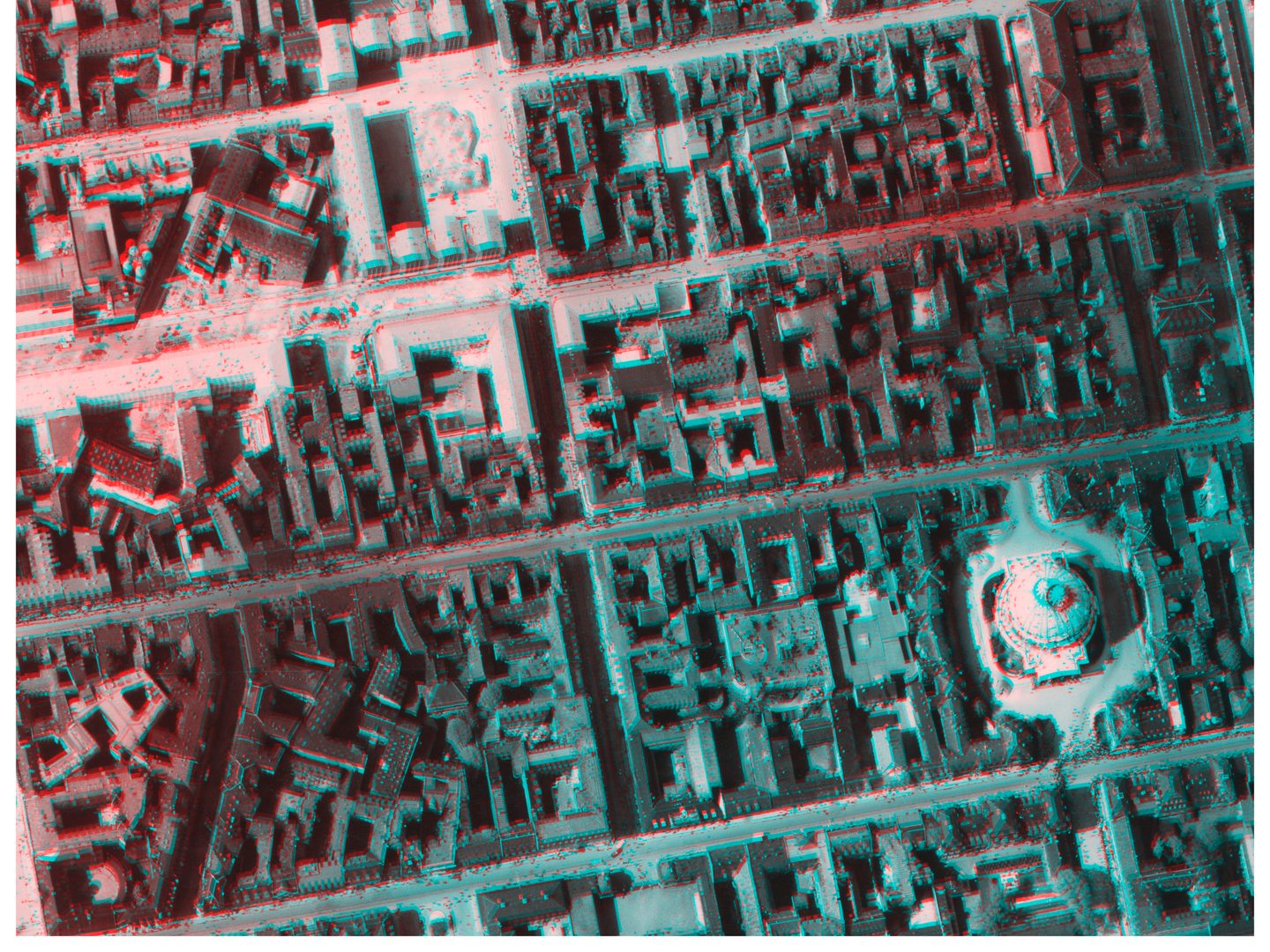 An image in blue and red tones of a city seen from above. The street grid is clear, as is a large domed building bottom right. The image is formed from 2 historic vertical aerial photos.