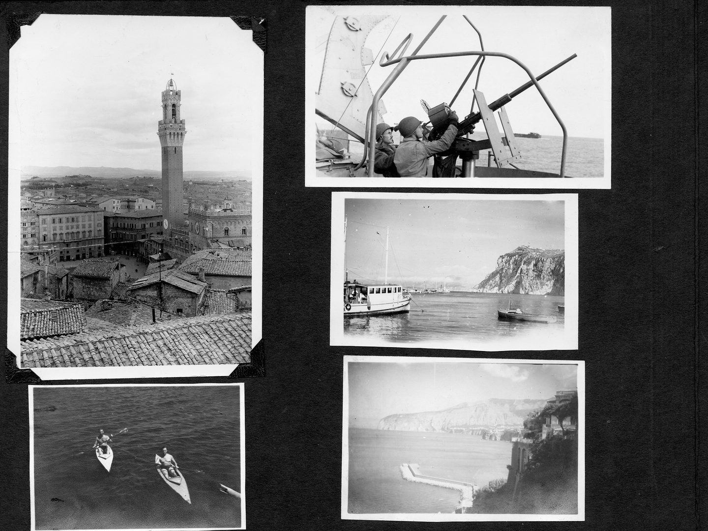 A black album page bearing 5 small historic black and white photos. Clockwise from top left, the photos show a bell tower in an Italian town, 2 soldiers manning an anti-aircraft gun on a ship, 2 vessels moored below cliffs, a seaside village and 2 men sitting in kayaks.