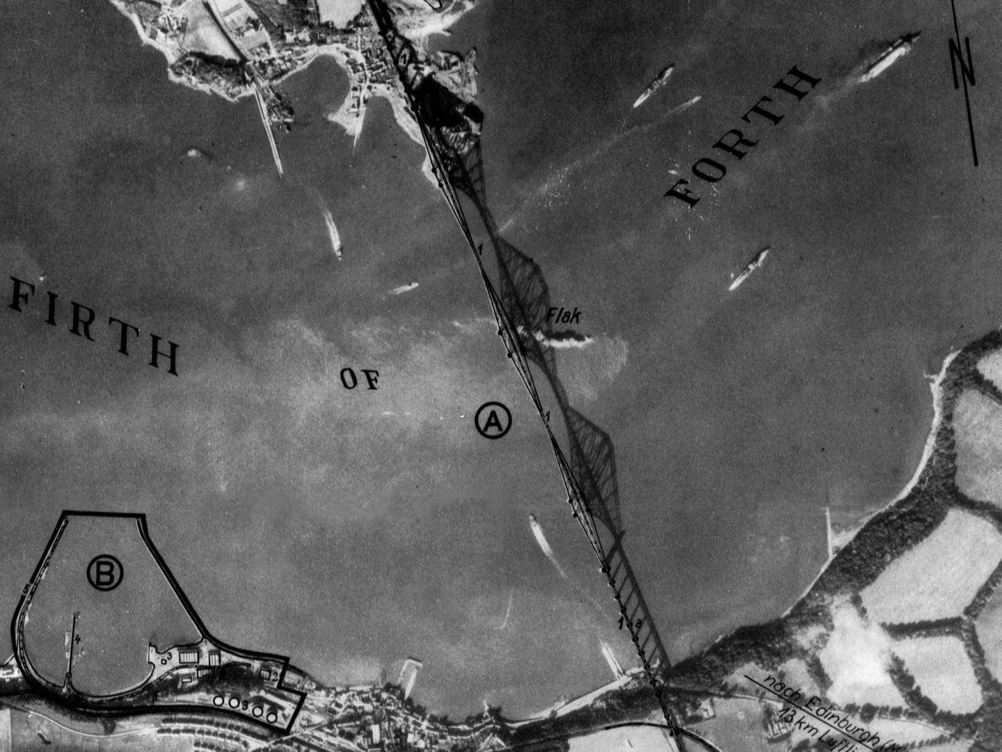 A black and white annotated aerial photo of the Forth Rail Bridge. The bridge and its shadow span the image vertically. The words ‘Firth of Forth’ have been written across it and the word ‘Flak’ in the middle marks the location of anti-aircraft guns.