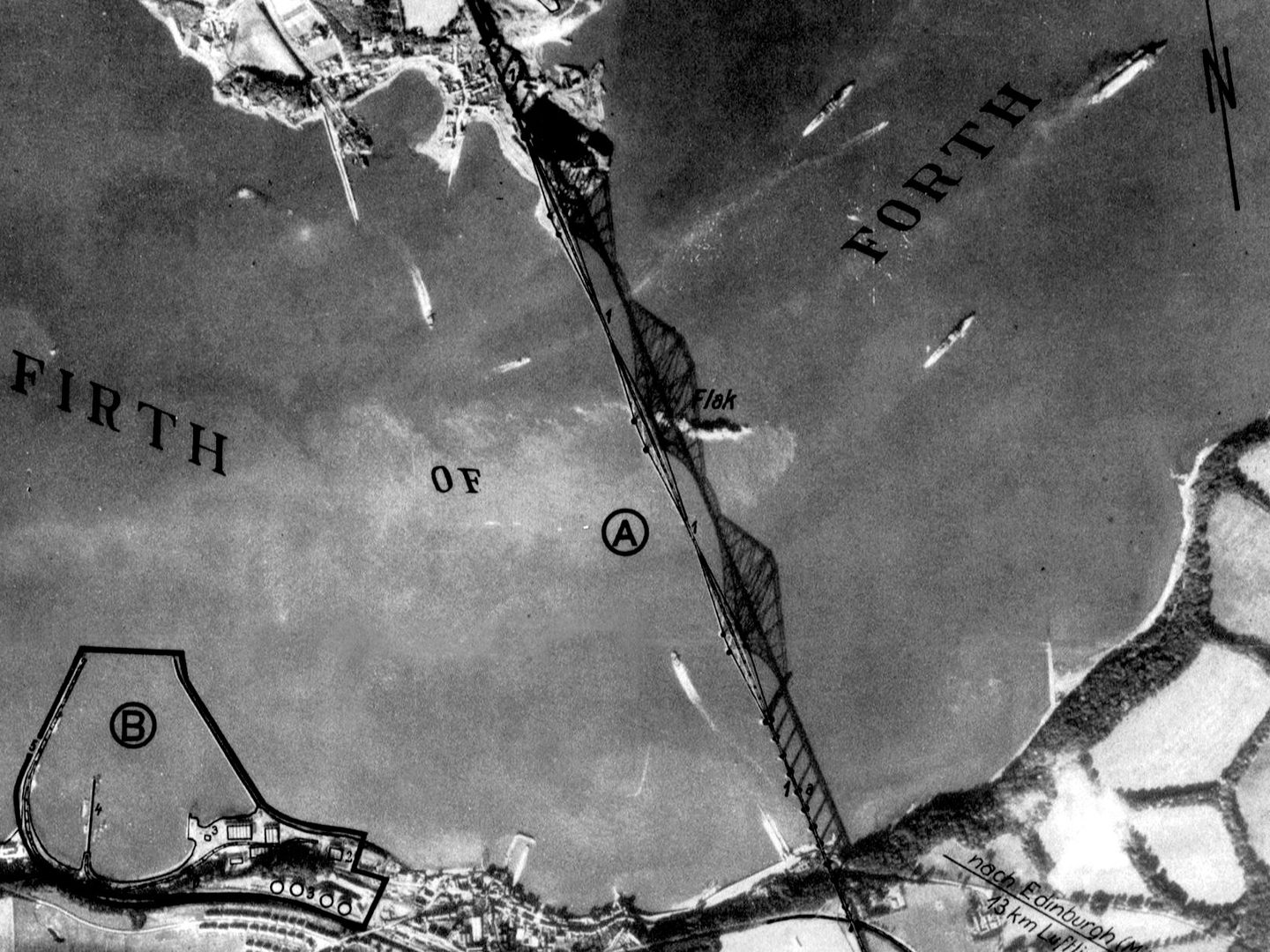 A black and white annotated aerial photo of the Forth Rail Bridge. The bridge and its shadow span the image vertically. The words ‘Firth of Forth’ have been written across it and the word ‘Flak’ in the middle marks the location of anti-aircraft guns.