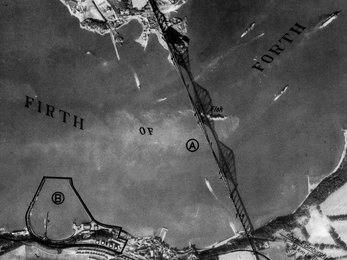 A black and white annotated aerial photo of the Forth Rail Bridge. The bridge and its shadow span the image vertically. The words ‘Firth of Forth’ have been written across it and the word ‘Flak’ in the middle marks the location of anti-aircraft guns.